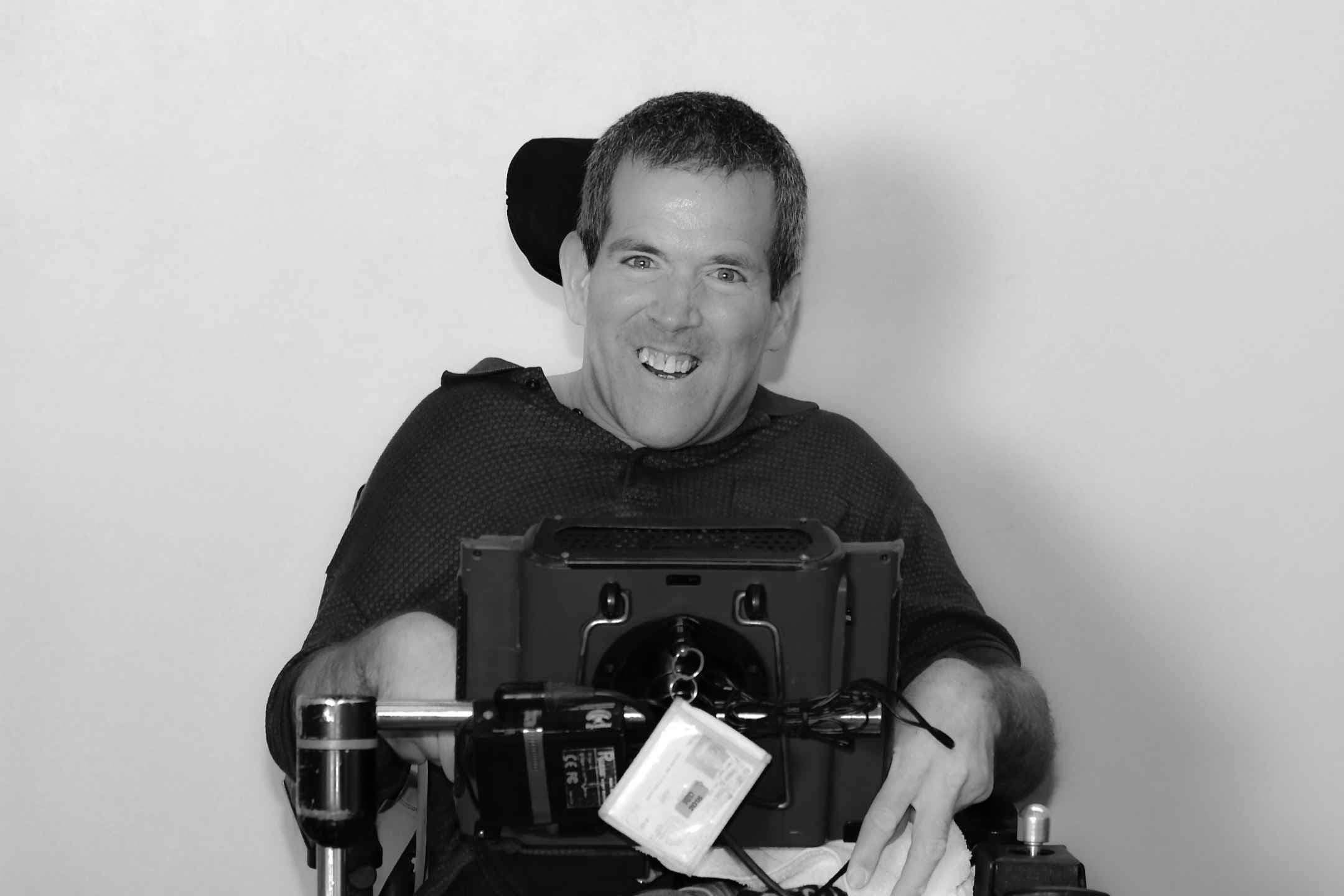 Mitch McKinney smiling in his power wheelchair